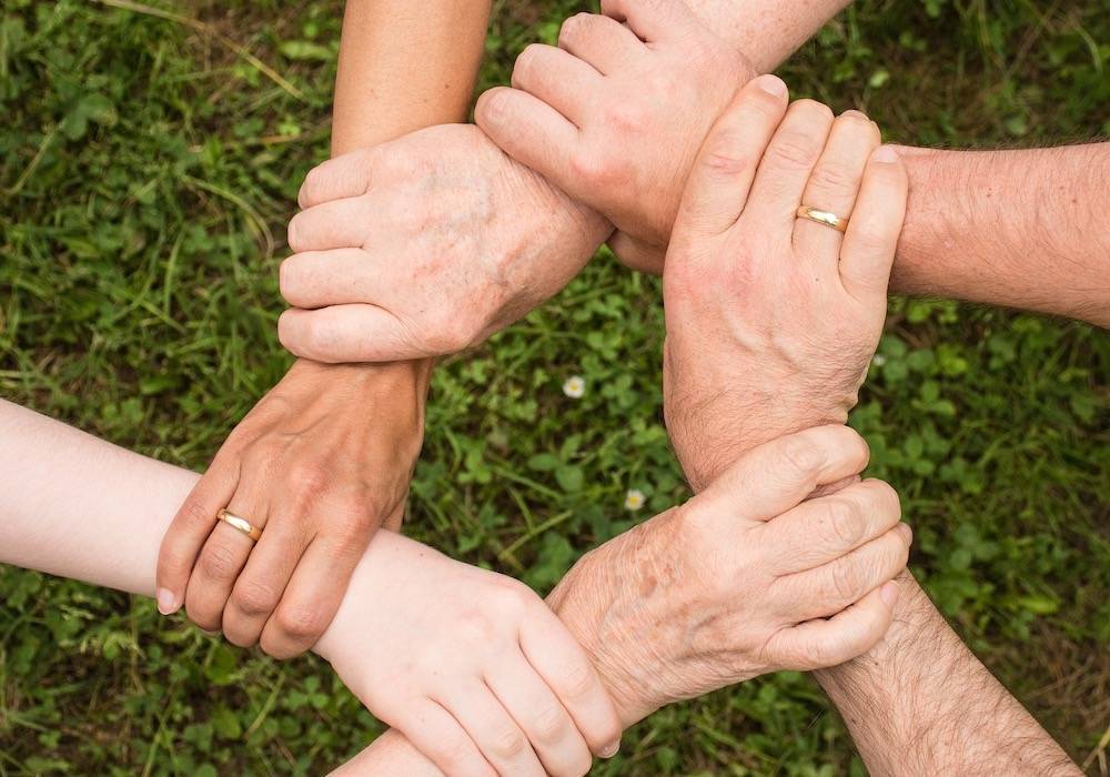 5 Hände im Kreis angefasst